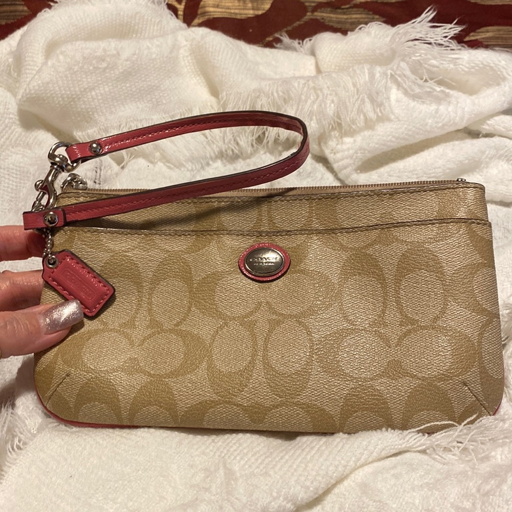 Coach tan signature C wristlet with pink leather trim.
